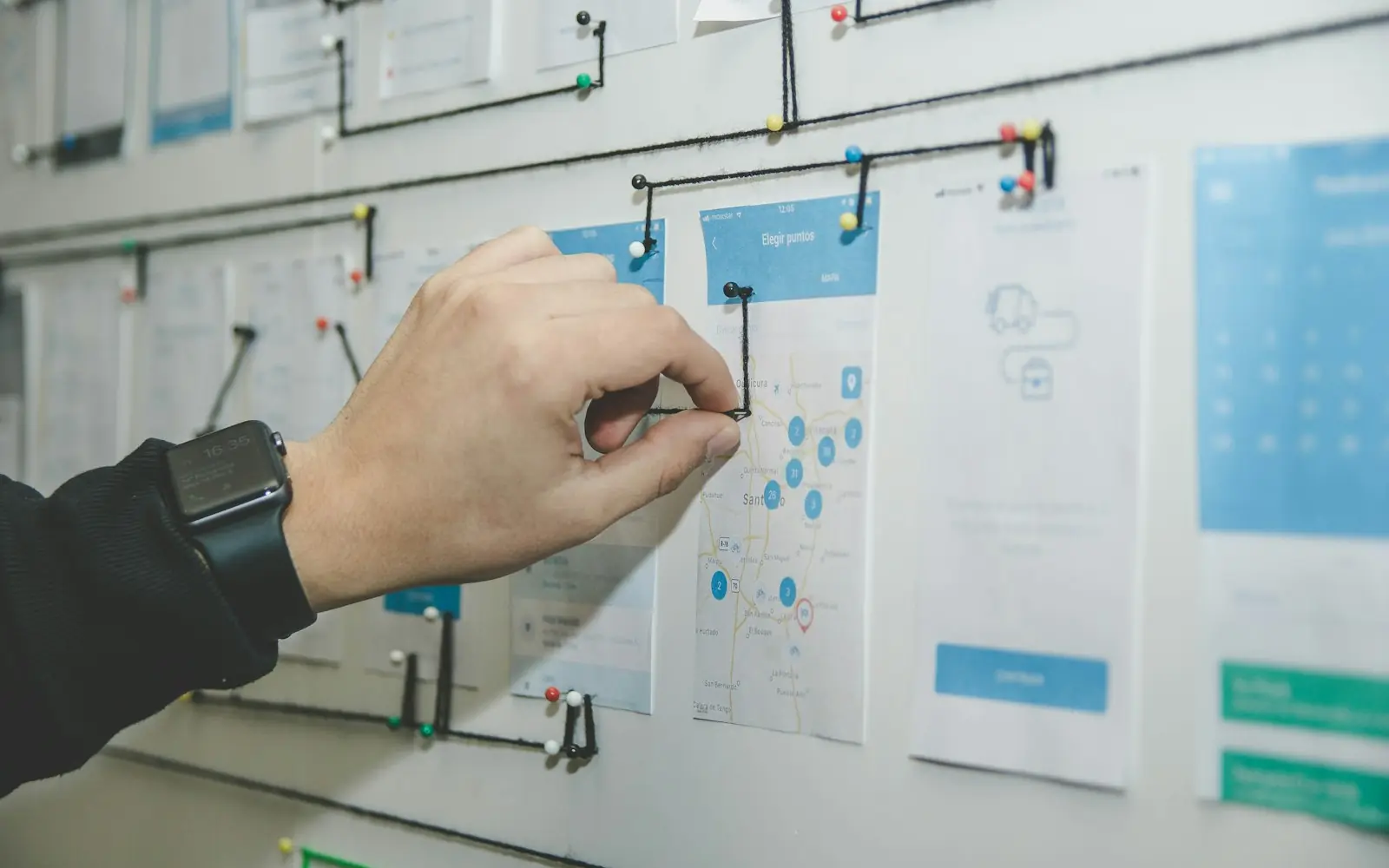 A person mapping a workflow on a wall board