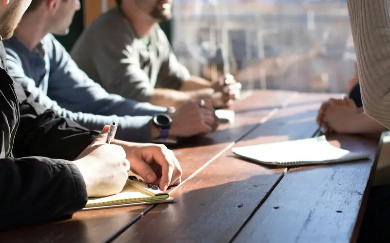 A team taking notes around a table during a workshop